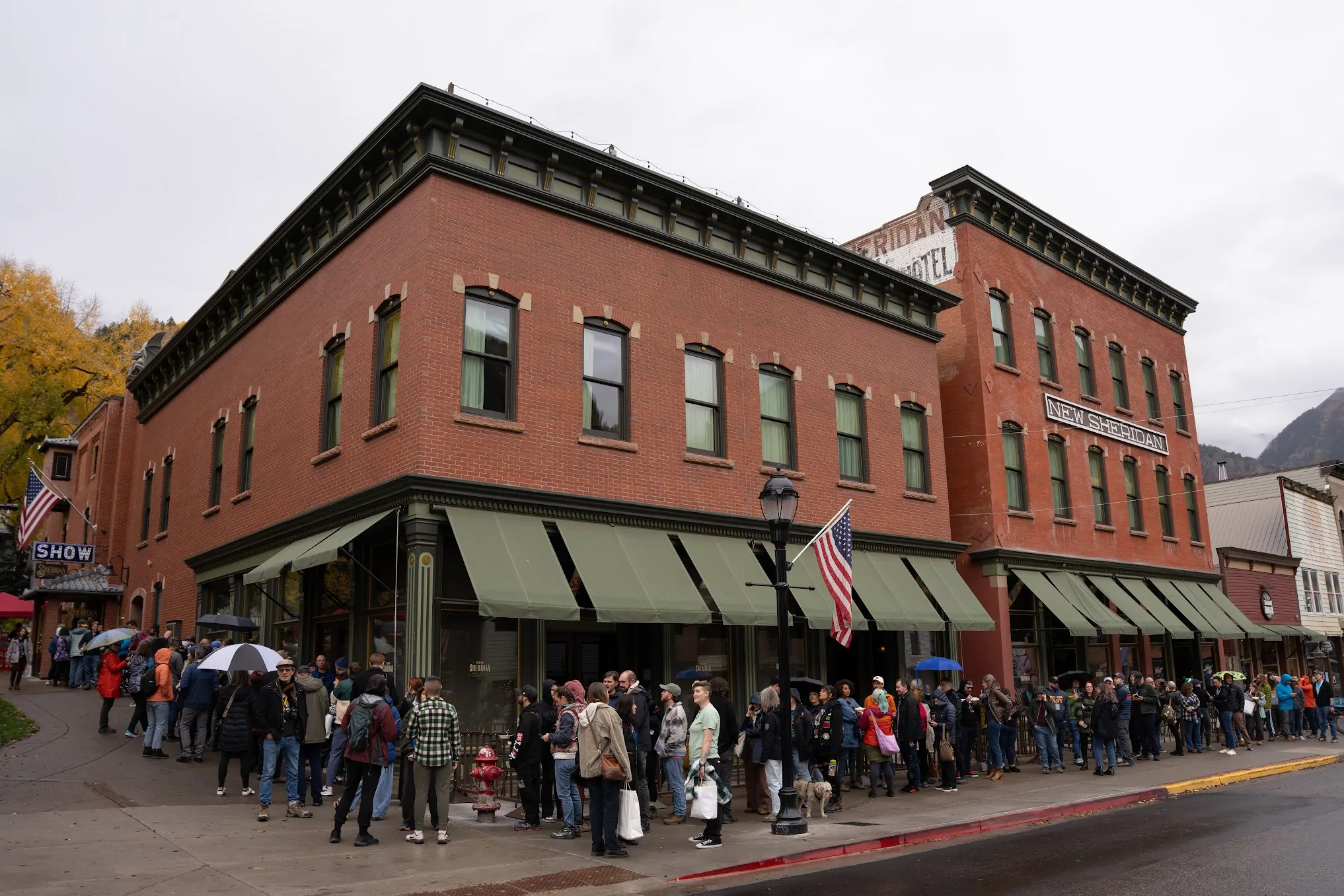 A long line wraps around the block of the Sheridan Opera House in Telluride on a rainy day